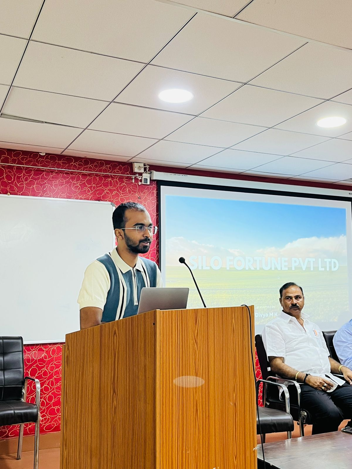Aftaab Hussain presenting at a podium during a Silofortune demonstration